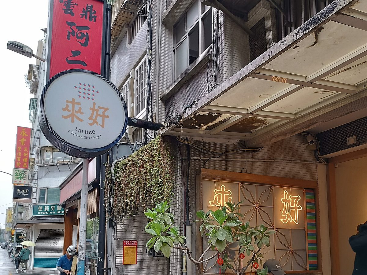 台北永康街騎樓旁的圓形招牌，中間是「來好」兩個大字，底下小字 LAI HAO 與 Taiwan Gift Shop，店門口的木窗上另有「來好」霓虹字