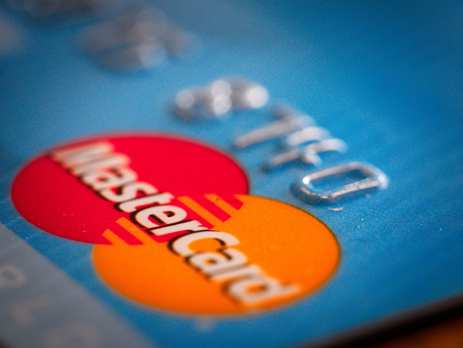 信用卡特寫，紅色與橘色兩個重疊的圓上橫寫著 MasterCard，重疊處是條紋