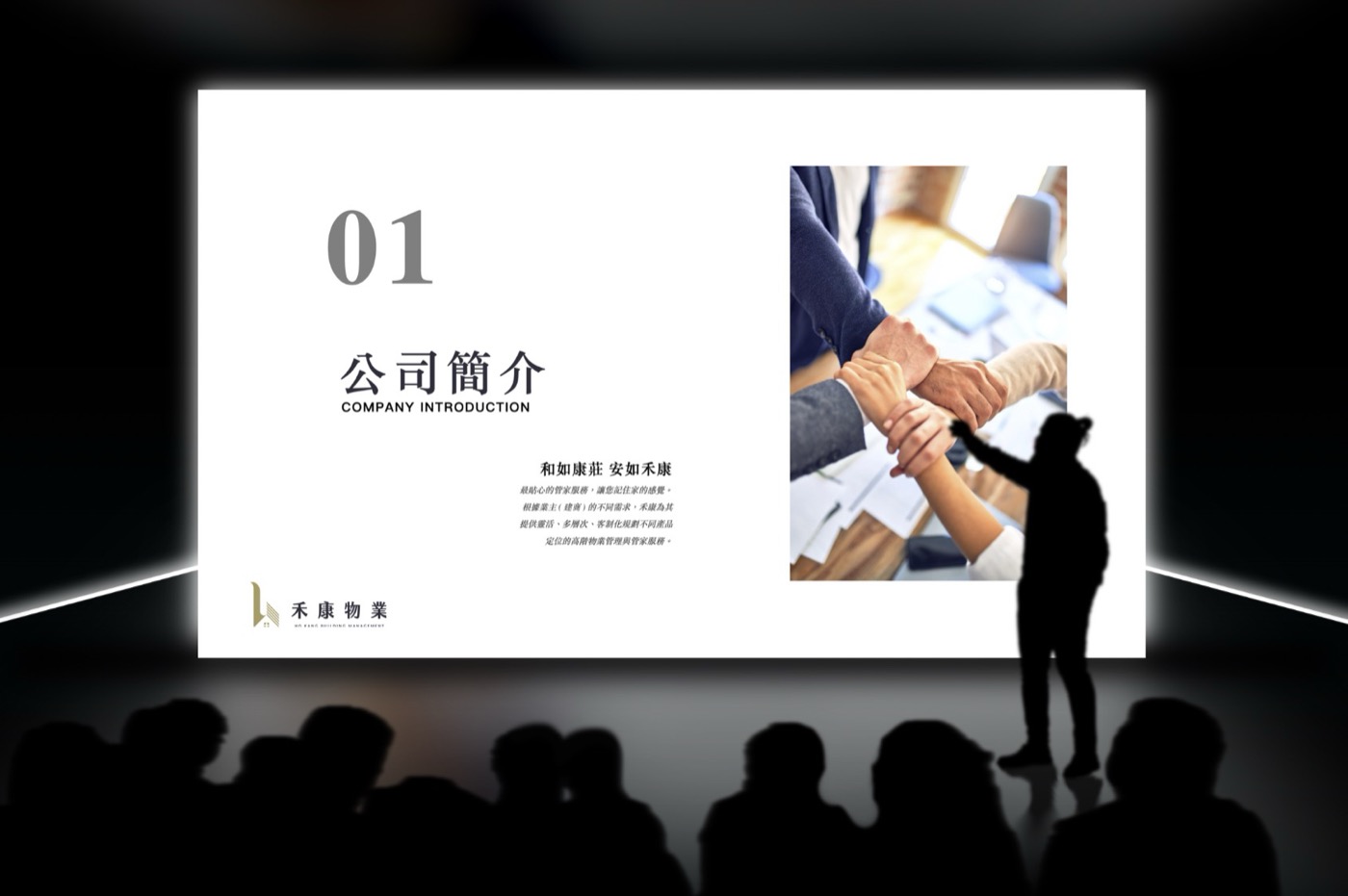禾康物業的品牌簡報投影在大螢幕上，畫面是公司簡介頁，前方坐著一排觀眾的剪影