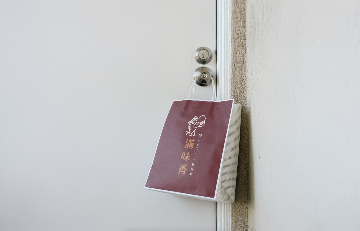 滿味香的名片吊掛在牆上,深紅底印著品牌標誌