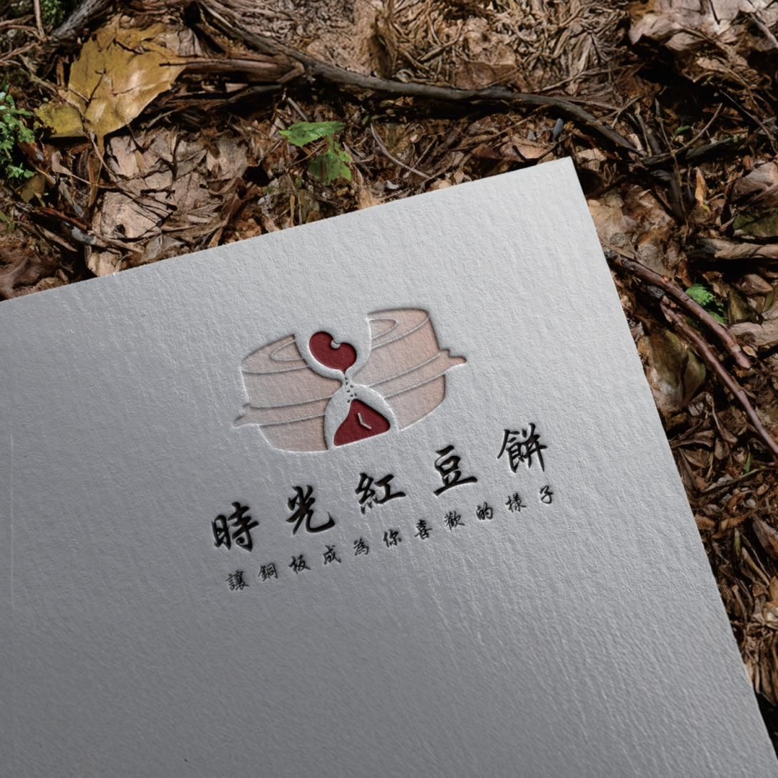 落葉上的白色紙卡,壓印出時光紅豆餅 logo 與標語