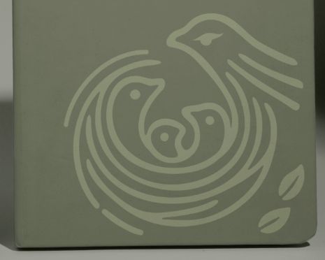 灰綠色筆記本封面上的淺色鷹巢 Logo 近照