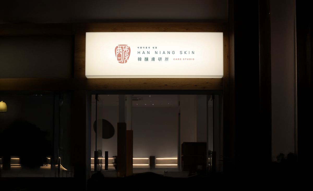 夜裡亮起的韓釀膚研所橫式燈箱,掛在玻璃門上方