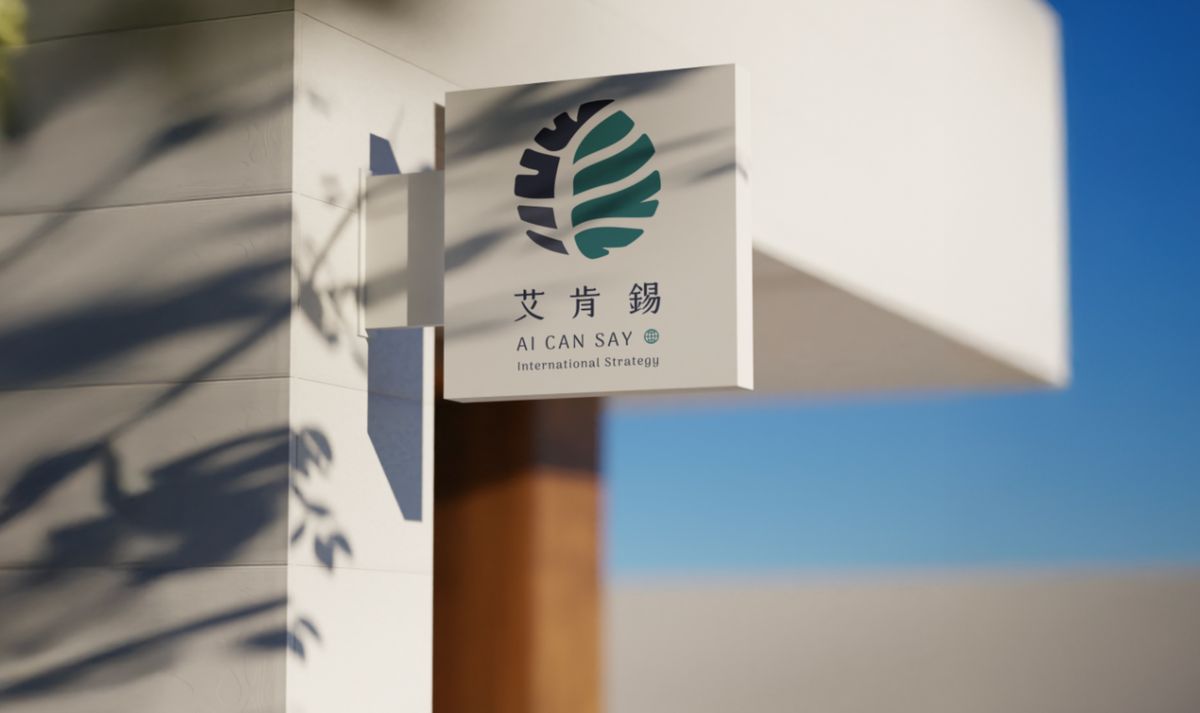 掛在白牆轉角的艾肯錫方形側招，印著大腦樹葉標誌與 AI CAN SAY