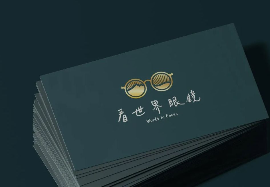 一疊深綠色名片，正面是金色看世界眼鏡標誌