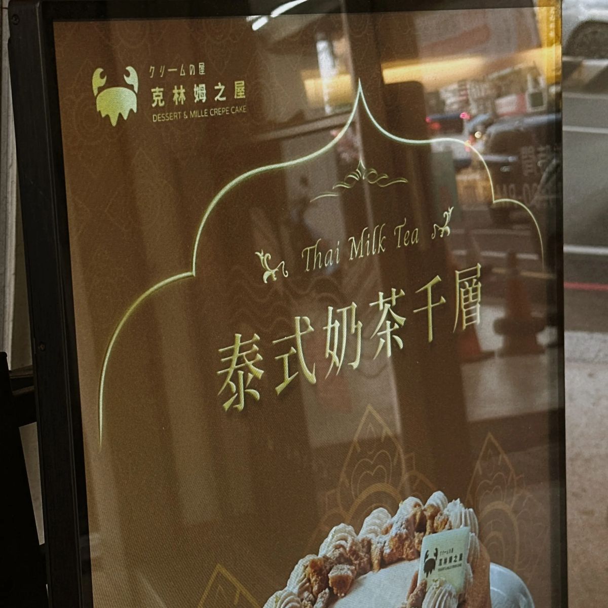 門口立牌上的泰式奶茶千層海報，左上角是克林姆之屋 Logo