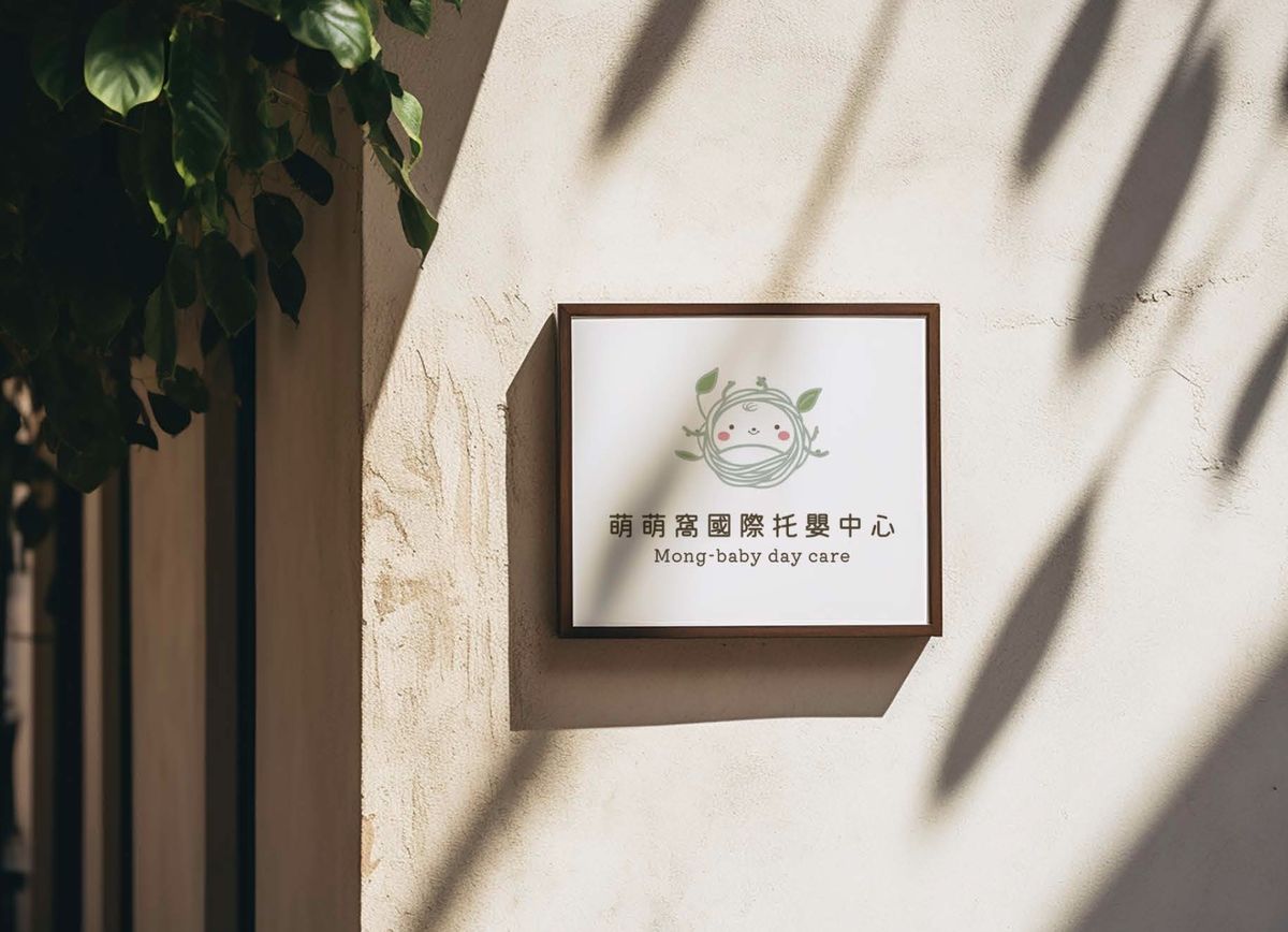灑著樹影的米色牆面上，掛著木框萌萌窩招牌