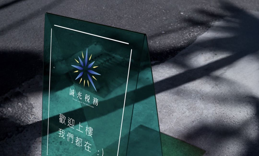 地上的透明綠色壓克力立牌，印著誠光稅務標誌和「歡迎上樓 我們都在」