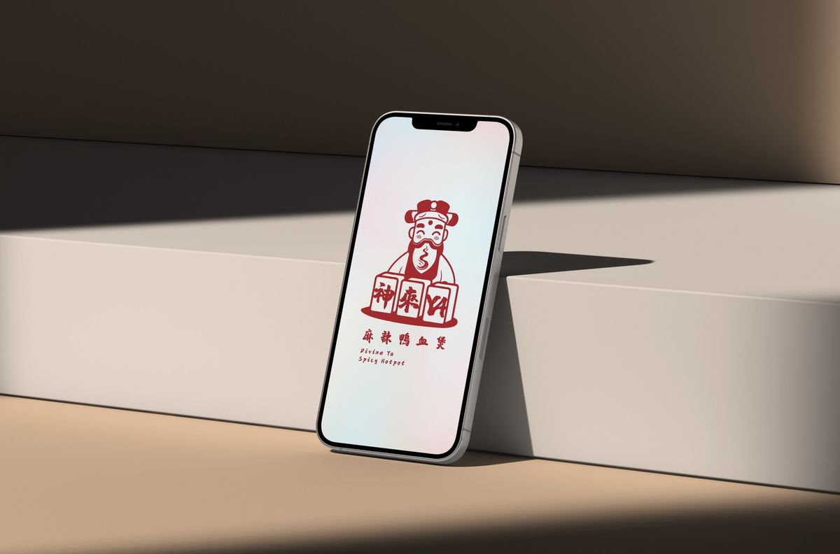 斜靠在白色台階上的手機，螢幕顯示紅色神來YA標誌