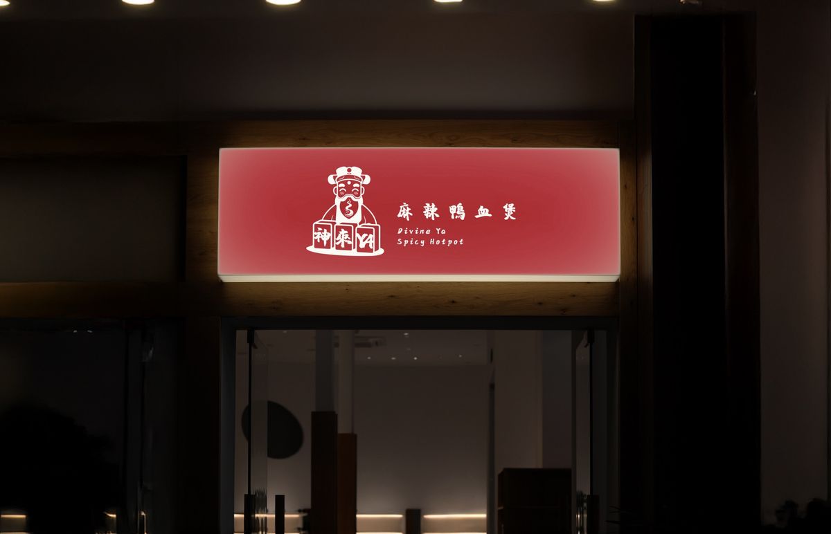 夜晚店門上方亮著紅色招牌，白色財神爺與麻辣鴨血煲字樣