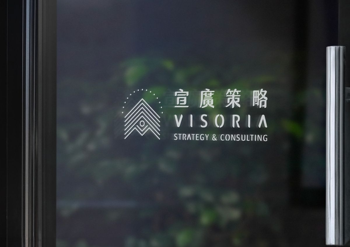 玻璃門上的白色宣廣策略橫式 Logo,後面透出綠色植物