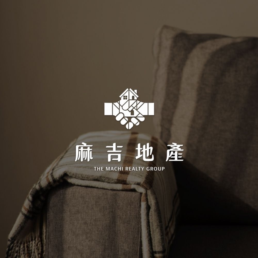 昏黃光線裡的沙發一角,畫面中央是白色麻吉地產 Logo 與 THE MACHI REALTY GROUP