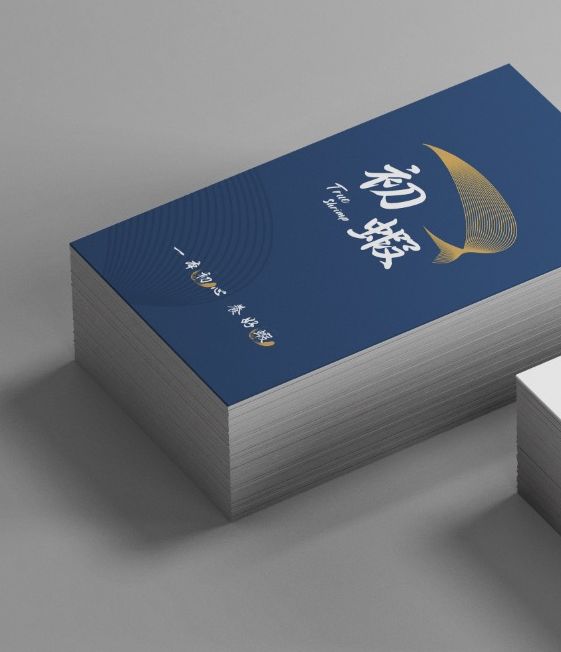 一疊深藍色名片,印著金色線條的初蝦標誌和標語