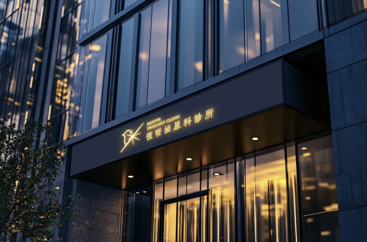恆昕泌尿科夜間店面，深色雨遮上的金色發光 Logo 與中英文字