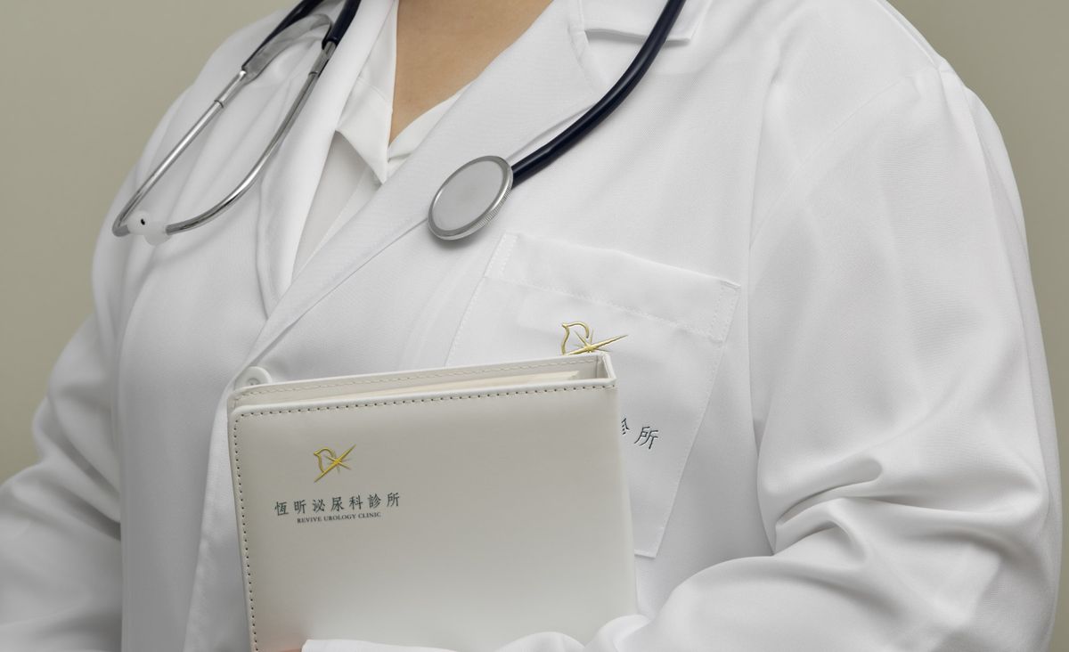 醫師白袍口袋與白色皮革資料夾上的恆昕金色 Logo