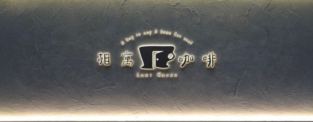 灰色手抹牆上的相寓咖啡立體字,背後透出暖黃光暈